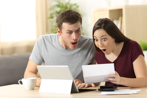 Couple looking at bills surprised